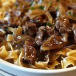 Delicious bowl of beef noodles topped with caramelized French onions.