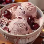 Delicious homemade cherry vanilla ice cream served in a bowl with cherries on top