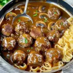 Gourmet meatballs served in creamy mushroom gravy with herbs and spices.