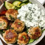 Delicious Greek chicken meatballs served with tzatziki sauce on a plate.