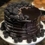 Slice of rich Midnight Velvet Cake topped with creamy frosting and chocolate shavings