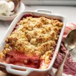 Delicious homemade rhubarb crumble served in a bowl with fresh cream.