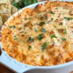 Creamy buffalo chicken dip served in a bowl with fresh vegetables and chips