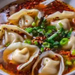 Bowl of delicious weeknight wonton soup garnished with green onions.